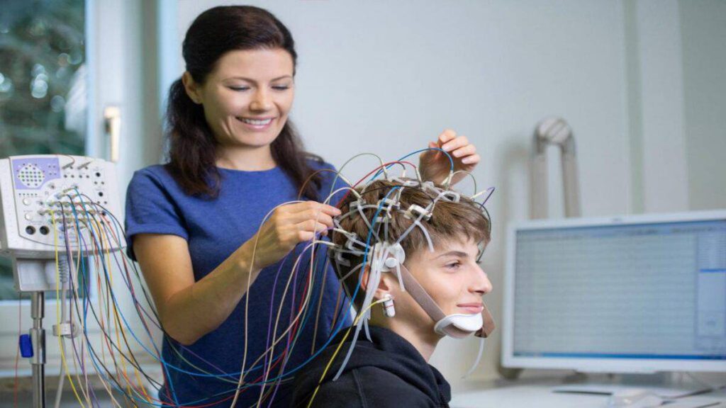 انجام نوار مغز توسط متخصص خانم دکتر متخصص که نوار مغر بیمار را می گیرد