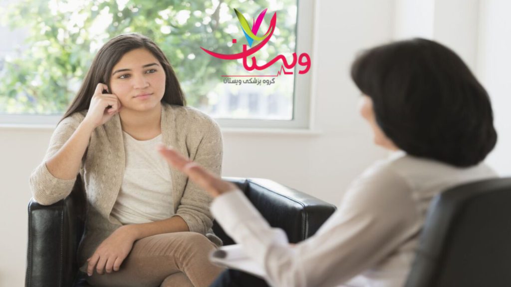 مراجعه به متخصص مغز و اعصاب متخصص مغز و اعصاب در حال صحبت با بیمار